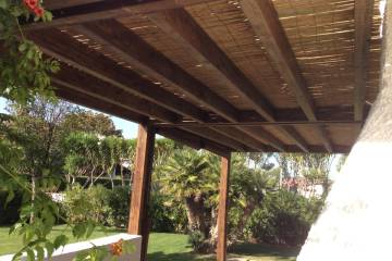 Pergola in legno con travi gemellati e cannucciato in bambu